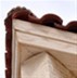 Corner of a tiled French wooden roof over brick walls 